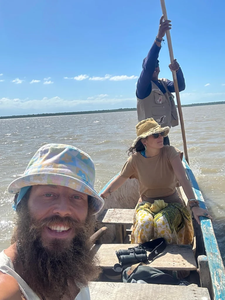 Benjy and Sofia travelling together by boat with a local guide